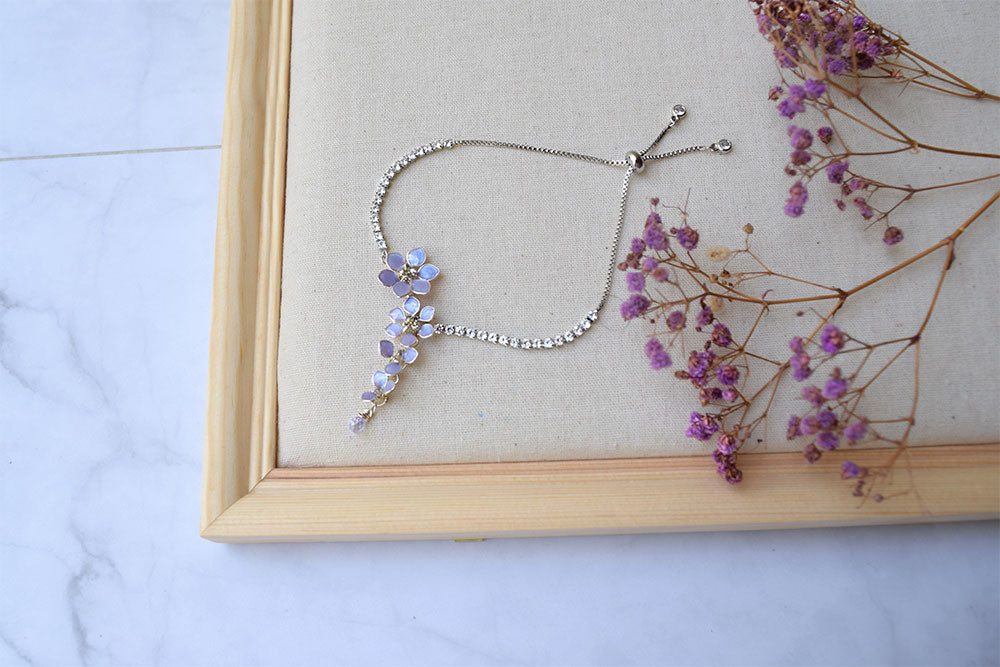 An elegant silver bracelet adjustable with slider.  Wrap around your wrist lavender flowers cascading from crystal chain. 