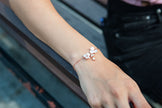 A handmade Rose gold adjustable bracelet with blush pink flowers.