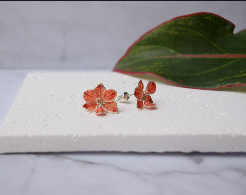A hand formed and hand-painted Peach-Red Orchid flower stud earrings.