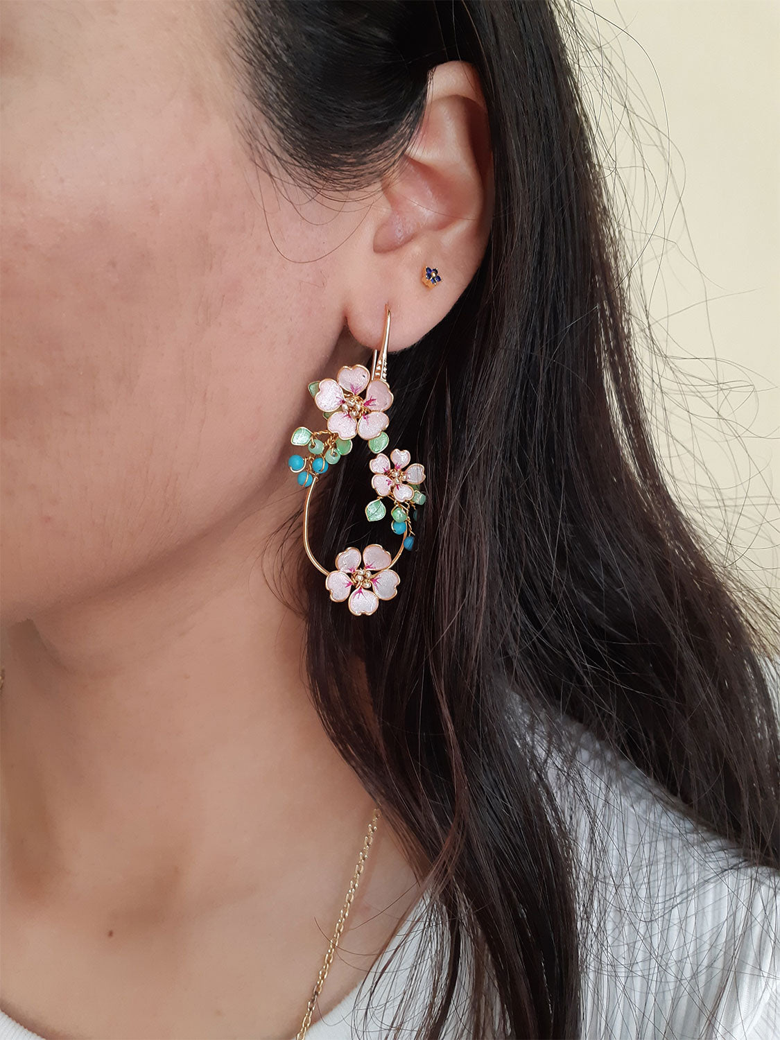 A beautiful handmade flower hoop earrings and a long plastron necklace in gold finish. Hoop earrings and long pendant hand formed and is a bunch of tiny pink Sakura flowers, pastel green leaves, Turquoise beads.