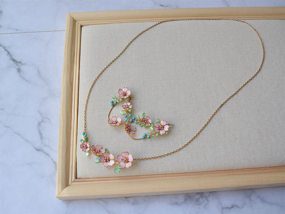A beautiful handmade flower hoop earrings and a long plastron necklace in gold finish. Hoop earrings and long pendant hand formed and is a bunch of tiny pink Sakura flowers, pastel green leaves, Turquoise beads.