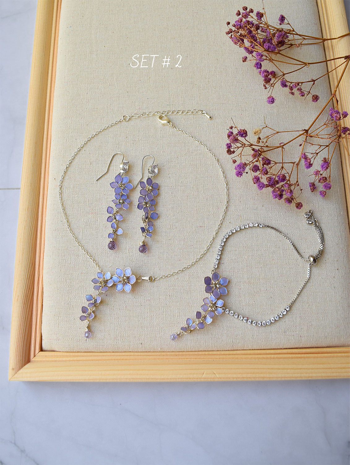 A delicate and elegant choker is handmade with tiny cascading Lavender/purple floral pendant with Zircon teardrop. Matching long earrings dangling with tiny flowers and a zircon. Lavender flower bridal bracelet is adjustable with slider and crystal chain. Excellent jewellery for Wedding, Prom or casual wear. 