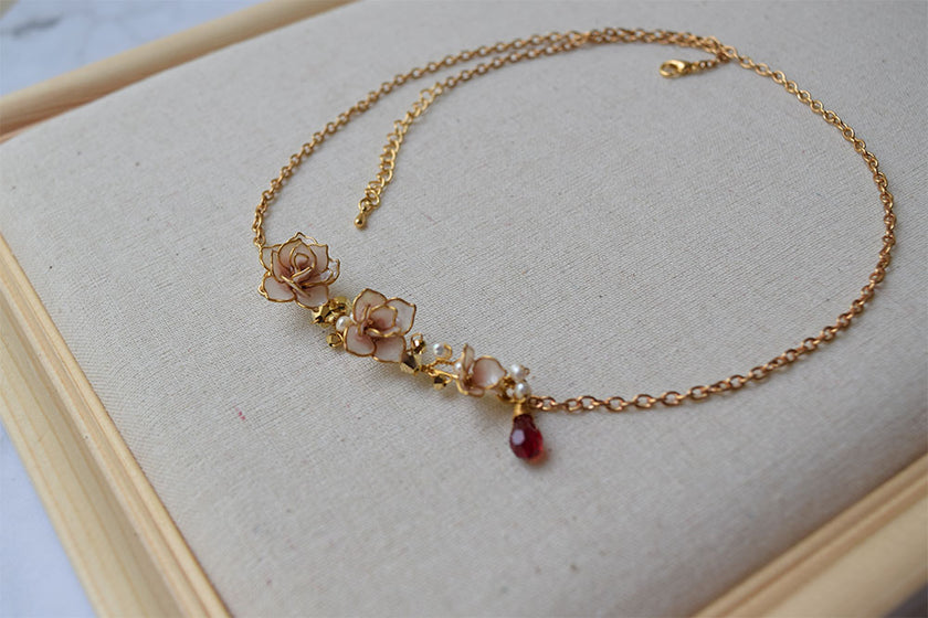 An elegant necklace and long earrings with hand formed Dusty Pink Rose flowers  with gold and red Swarovski crystals with fresh water pearls