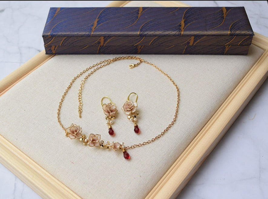 An elegant necklace and long earrings with hand formed Dusty Pink Rose flowers  with gold and red Swarovski crystals with fresh water pearls