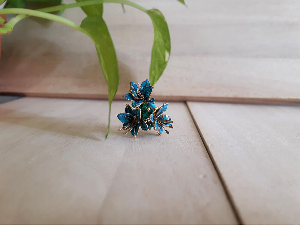 A bright and bold cocktail finger ring adjustable with 3 teal Lily flowers and turquoise beads