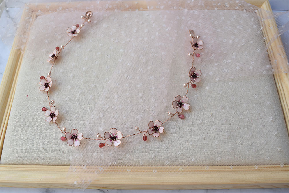 A Delicate 18 inches bridal hair vine in rose gold finish with handmade tiny Sakura/Cherry Blossom flowers in arranged in a row in combination with pink pearls and glass beads. A unique bridal pink hair wrap or hair garland in rose gold finish.