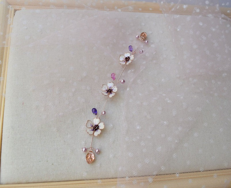 A Delicate hair vine in rose gold finish with handmade tiny Sakura flowers in lavender shades arranged in a row in combination with lavender pearls and glass beads. A unique bridal violet hair wrap or hair garland in rose gold finish.