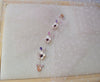 A Delicate hair vine in rose gold finish with handmade tiny Sakura flowers in lavender shades arranged in a row in combination with lavender pearls and glass beads. A unique bridal violet hair wrap or hair garland in rose gold finish.