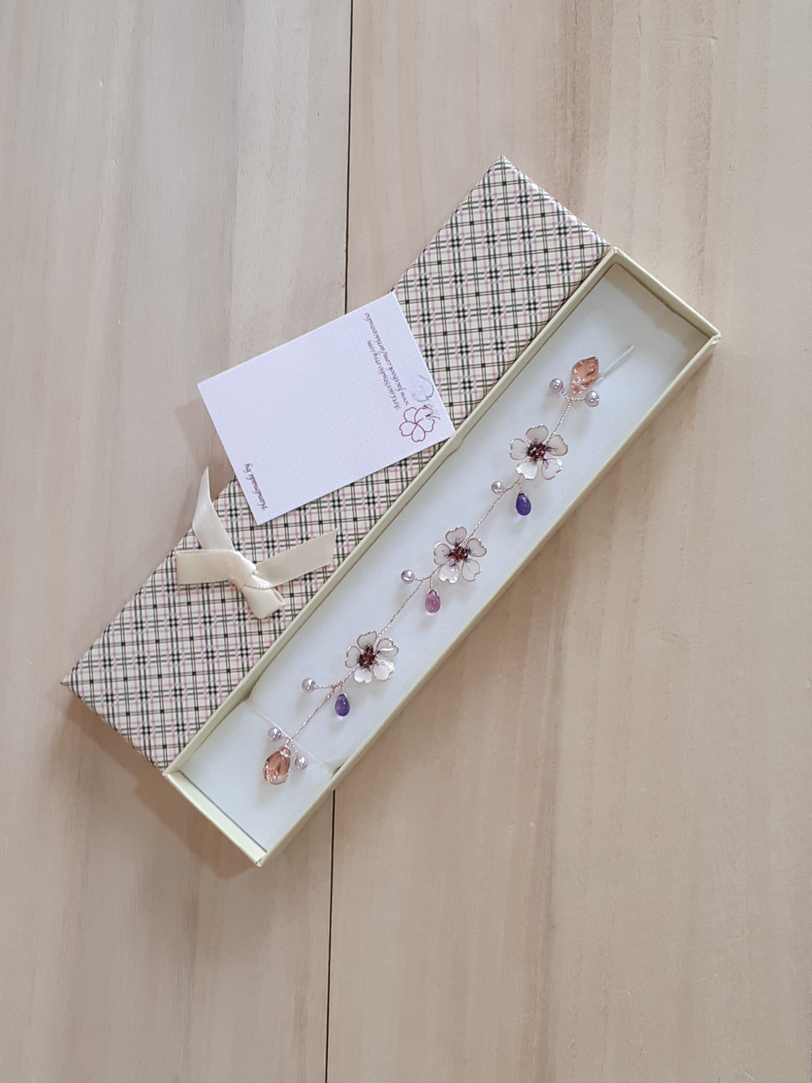 A Delicate 6 inches long hair vine in rose gold finish with handmade tiny Sakura flowers in lavender shades arranged in a row in combination with lavender pearls and glass beads. A unique bridal violet hair wrap or hair garland in rose gold finish.