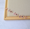 A Delicate 6 inches long hair vine in rose gold finish with handmade tiny Sakura flowers in lavender shades arranged in a row in combination with lavender pearls and glass beads. A unique bridal violet hair wrap or hair garland in rose gold finish.