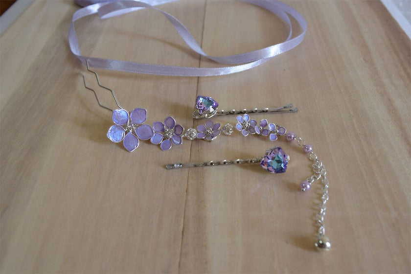 A handmade dangling bridal hair fork, short hair vine with violet/lavender handmade tiny flowers cascading on a chain, pearls and tiny bells.